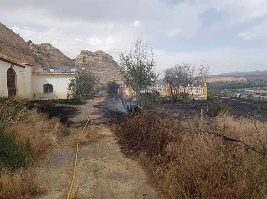 Bomberos de Guadix e Infoca participan en la extinción de un incendio de matorral en la carretera A-4100